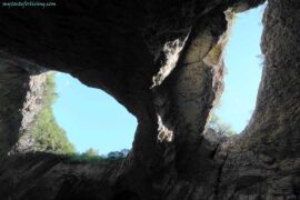 Синьо небе над Деветашката пещера - отвор на пещерата, през който се вижда синьото небе и зеленина, стърчаща от скалите