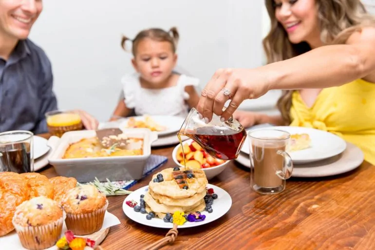 The table with a varied breakfast spread on a wooden surface.